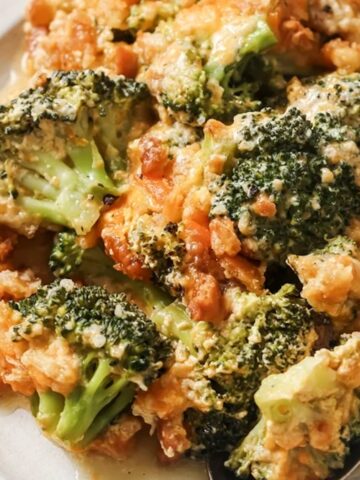 A plate of broccoli casserole with cheese and breadcrumbs.