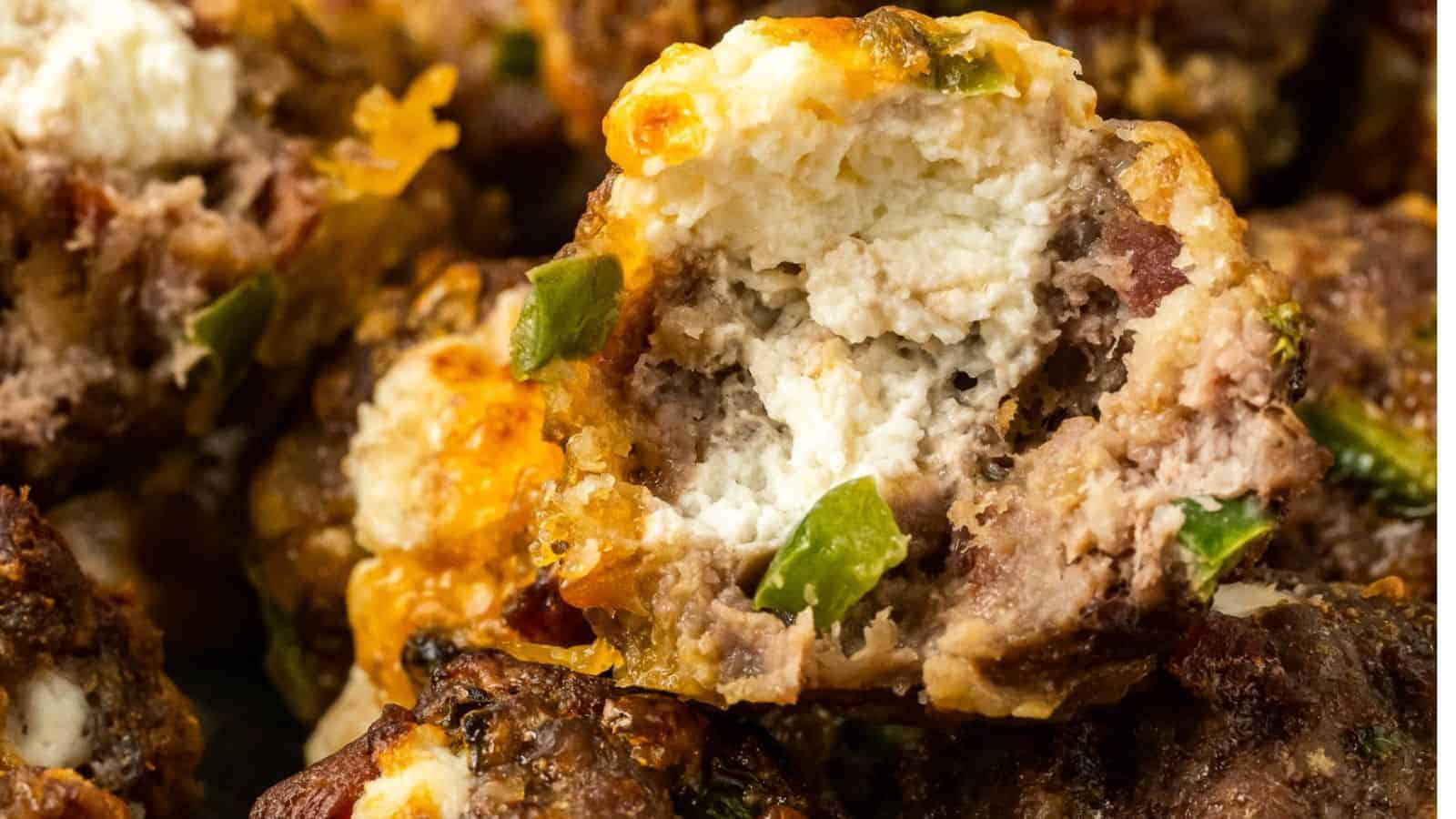 Close-up of stuffed meatballs with visible chunks of cheese and green peppers.