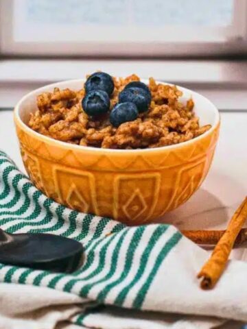 Chai Rice Pudding in a bowl top with fresh blueberries.