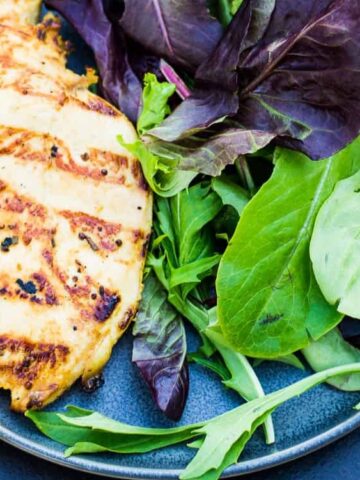 grilled chicken with different kinds of lettuce in a plate