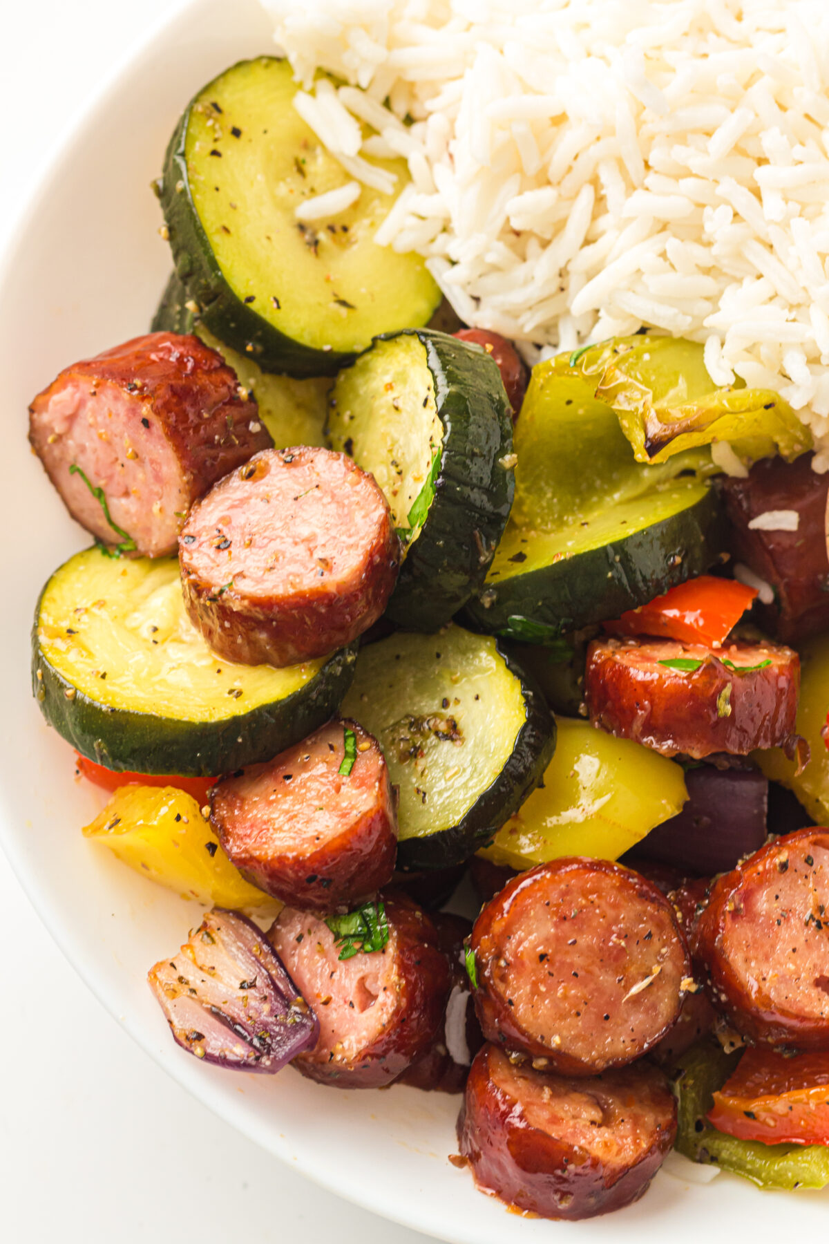 roasted sausage and veggies with rice in a bowl.