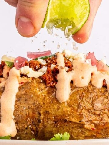 Loaded Chorizo Baked Potato in a plate squeezed with lemon.