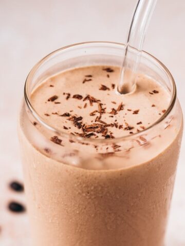 Tahini Chip Cold Brew Shake in a glass with a glass straw.