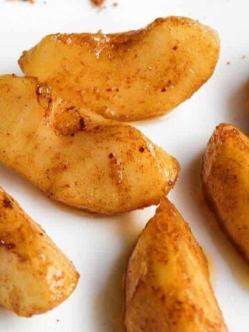 slices of apple coated in a butter with cinnamon