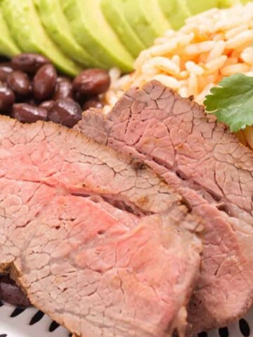 beef , rice , red beans and avocado in a plate