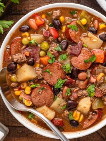 combination of three types of meat, beans, and veggies with broth soup in a bowl