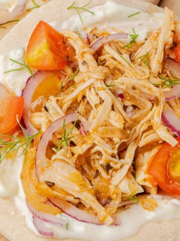 pita bread with shredded chicken, tomatoes, onion, cucumber and white sauce