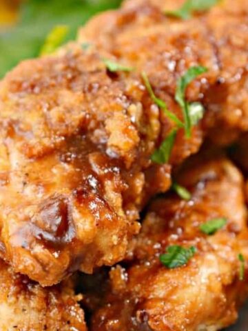 air fried chicken sprinkled with green leaves ion a plate.