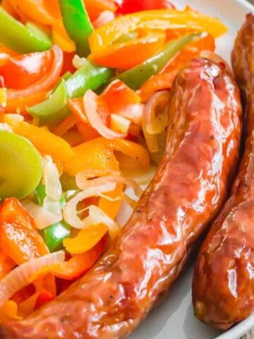 air fryer Italian sausage with peppers and onions on a plate.