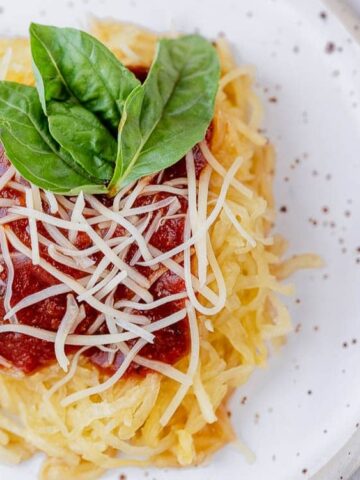 cut squash into spaghetti strips with tomato sauce on top and grated cheese. garnish with basil on the plate