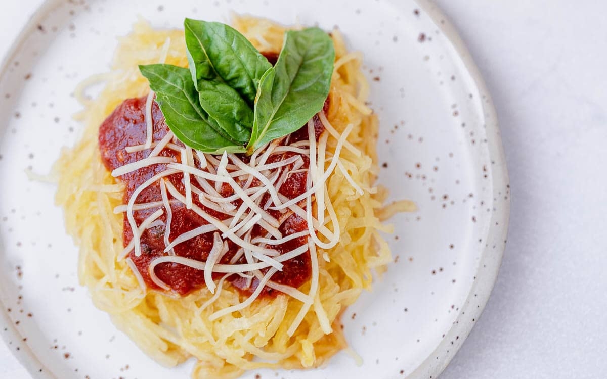 cut squash into spaghetti strips with tomato sauce on top and grated cheese. garnish with basil on the plate