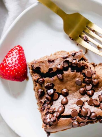 chocolate baked oats with strawberry on the side and fork on a plate