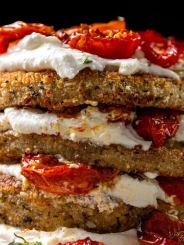 fried eggplant with dried cherry tomatoes and whipped cream in a plate