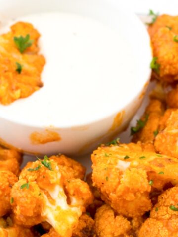 orange cauliflower with white dip sauce on the plate