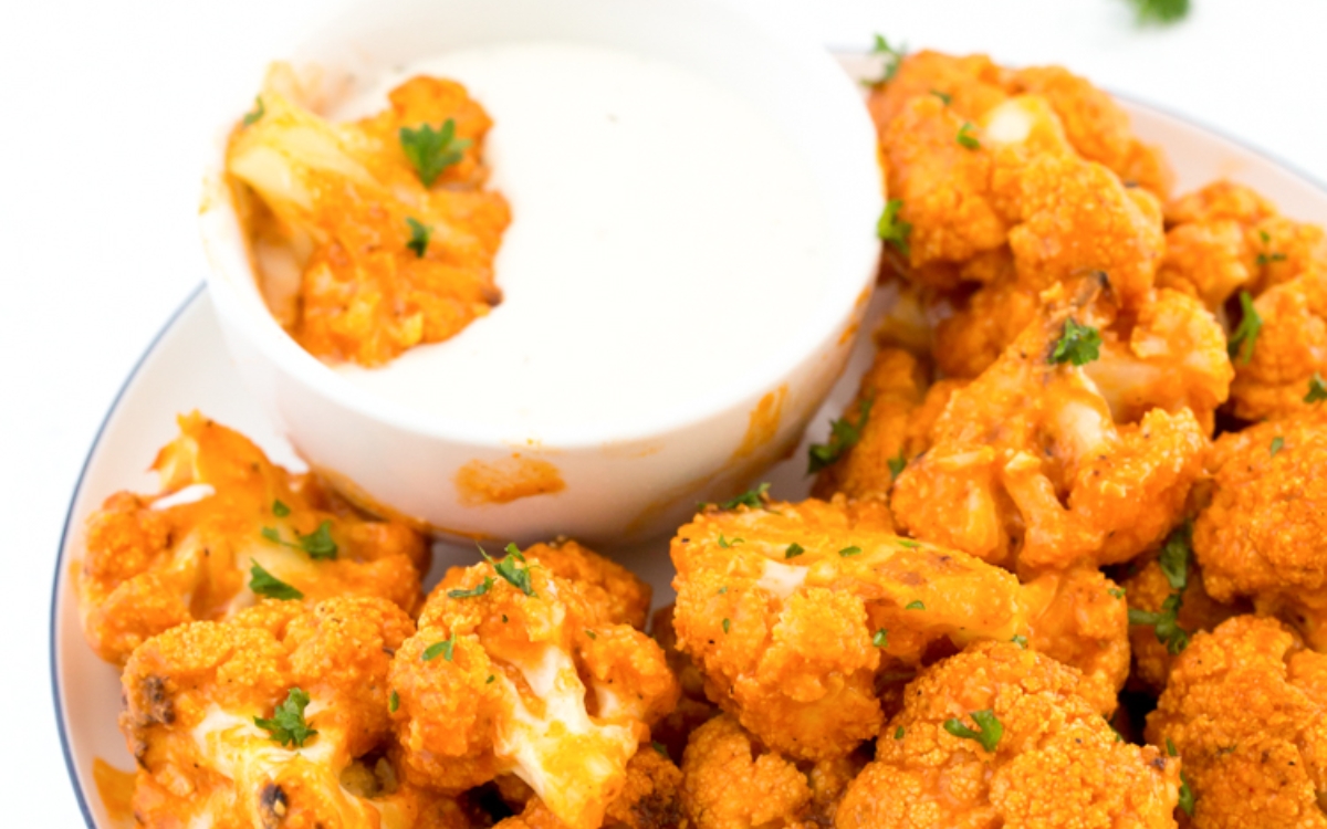orange cauliflower with white dip sauce on the plate