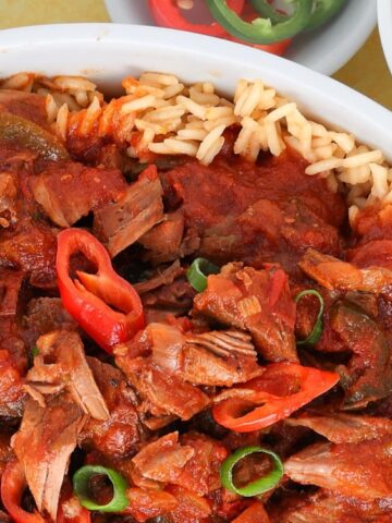 rice top with thick red sauce with beef, bell pepper and onion leaks in a platter