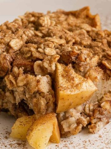 slice of pie made with apple, oats, and pecan nuts and cinnamon on a plate.
