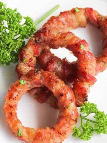 Bacon Wrapped Onion Rings garnish with parsley on a plate