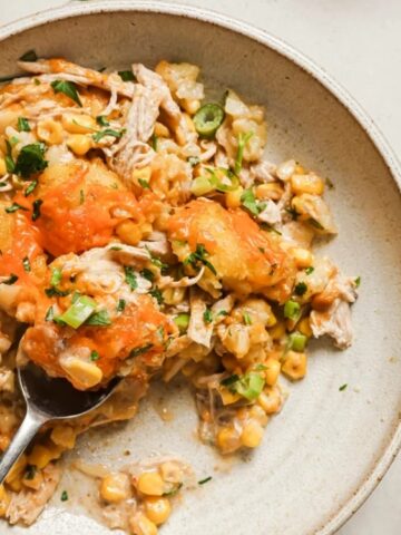 cheesy chicken tater tot on a plate with a spoon