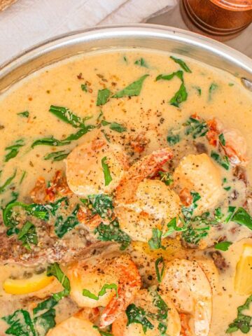creamy light orange soup with shrimp, sundried tomatoes , dried oregano, lemon on a pot