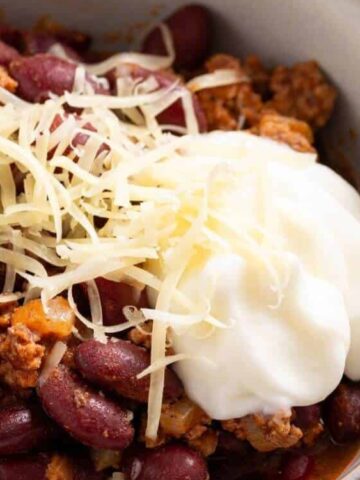 dark red kidney beans, ground beef on a bowl top with grated cheese
