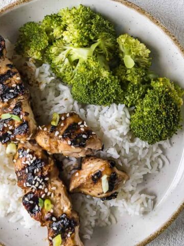 Grilled Teriyaki Chicken Skewers on a plate with rice and broccoli on the side