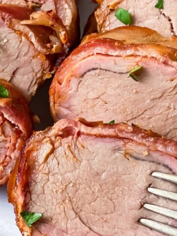 Smoked Bacon Wrapped Pork Tenderloin on a plate with fork