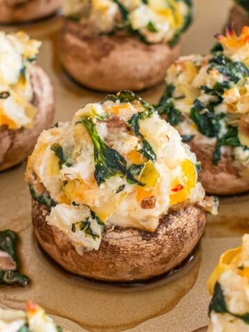 mushroom stuffed with cream cheese, spinach, sour cream and topped with grated cheddar cheese