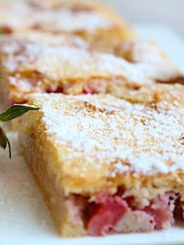 strawberry coffee cake sprinkled with extra streusel and fresh strawberry fruit in the side