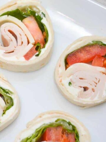 turkey meat, cheese, tomato sliced, lettuce leaves rolled in a flour tortillas