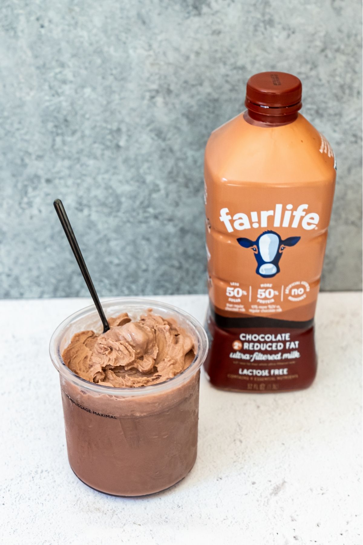 Chocolate Fairlife milk ice cream with a bottle of fairlife chocolate