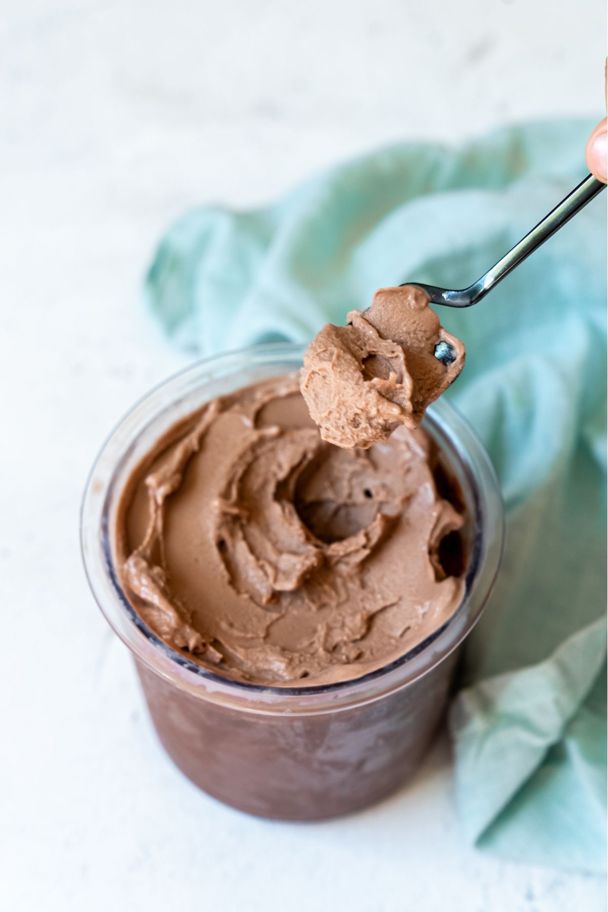 Chocolate Fairlife milk ice cream with spoon and a blue napkin