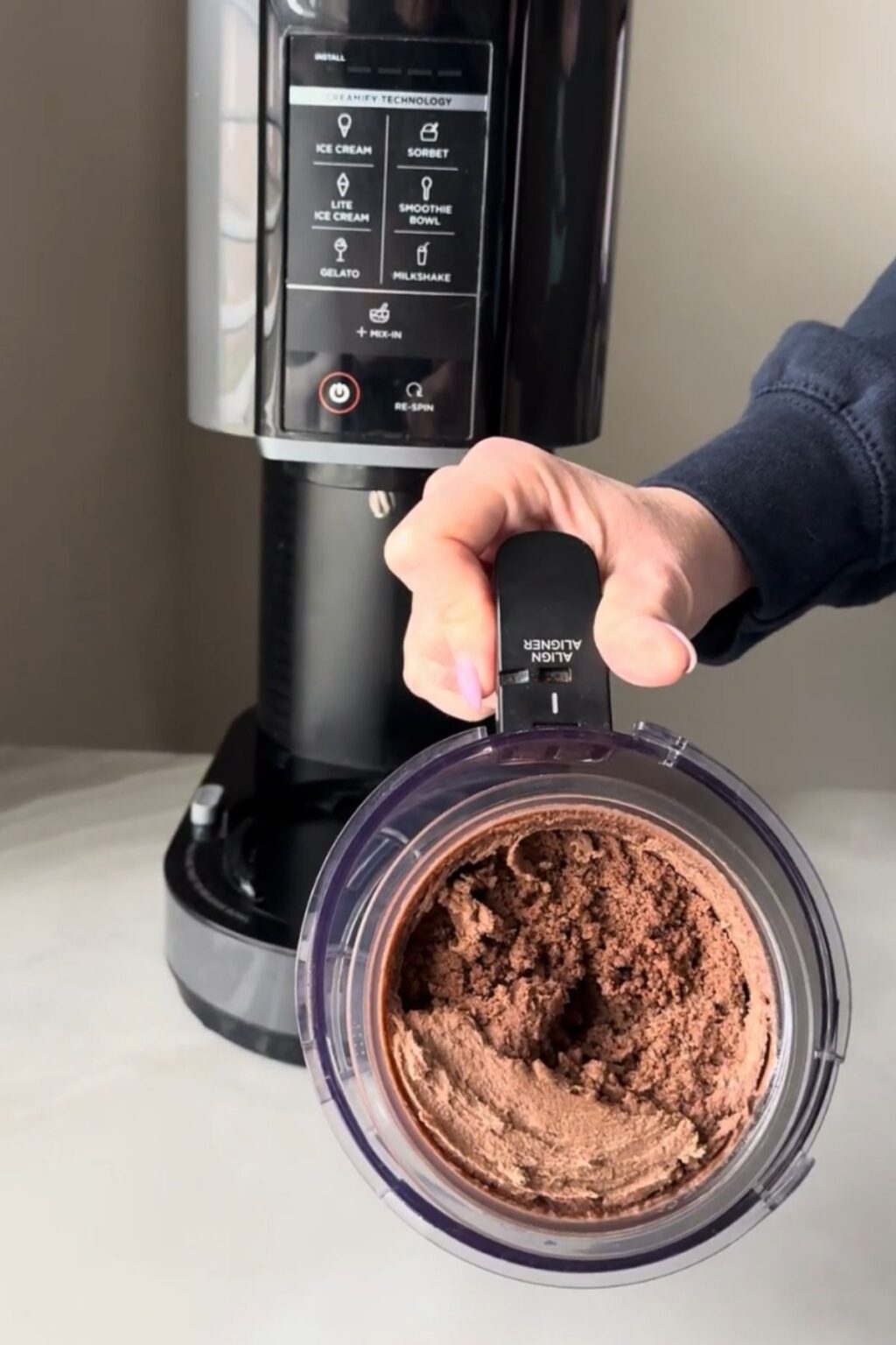 Top-down view of a Ninja Creami pint holding crumbly, churned chocolate malt ice cream after the initial spin, ready for re-spin or mix-ins to achieve creamy texture for Ninja Creami Chocolate Malt Ice Cream.