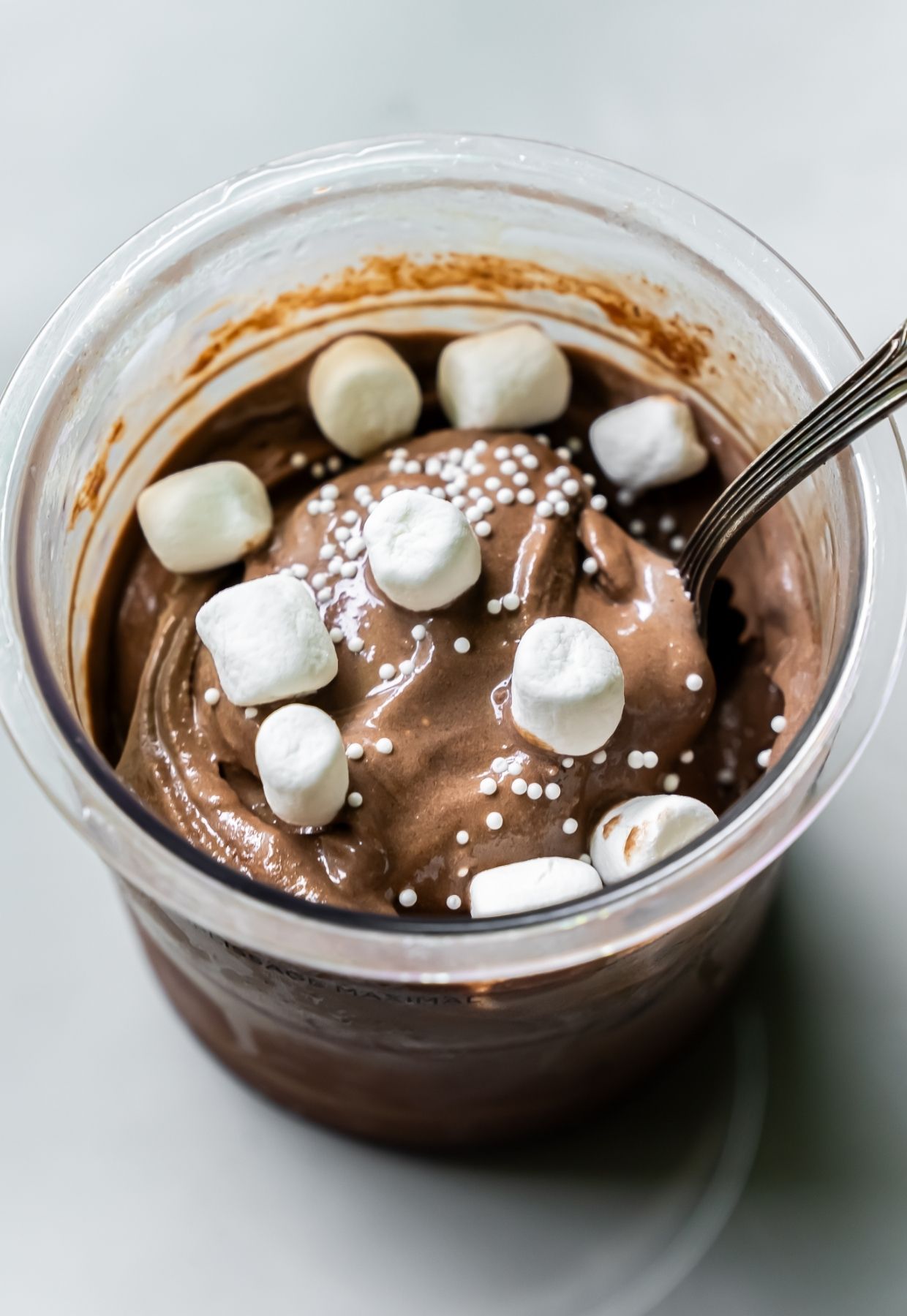 Dark Chocolate Protein Ice Cream with marshmallow, and spoon.