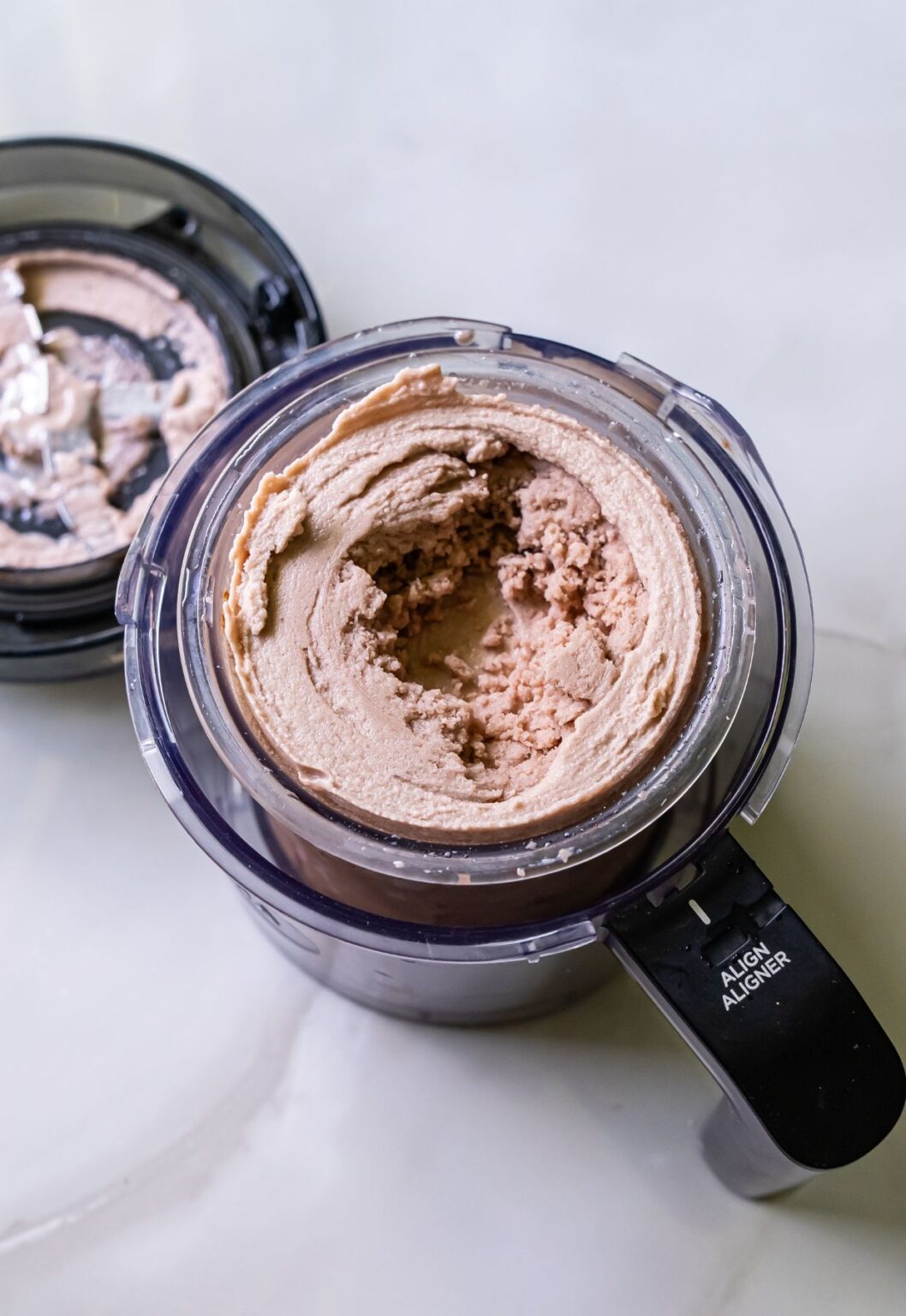 Top view of high protein chocolate ice cream swirled in a clear Ninja blender pint.