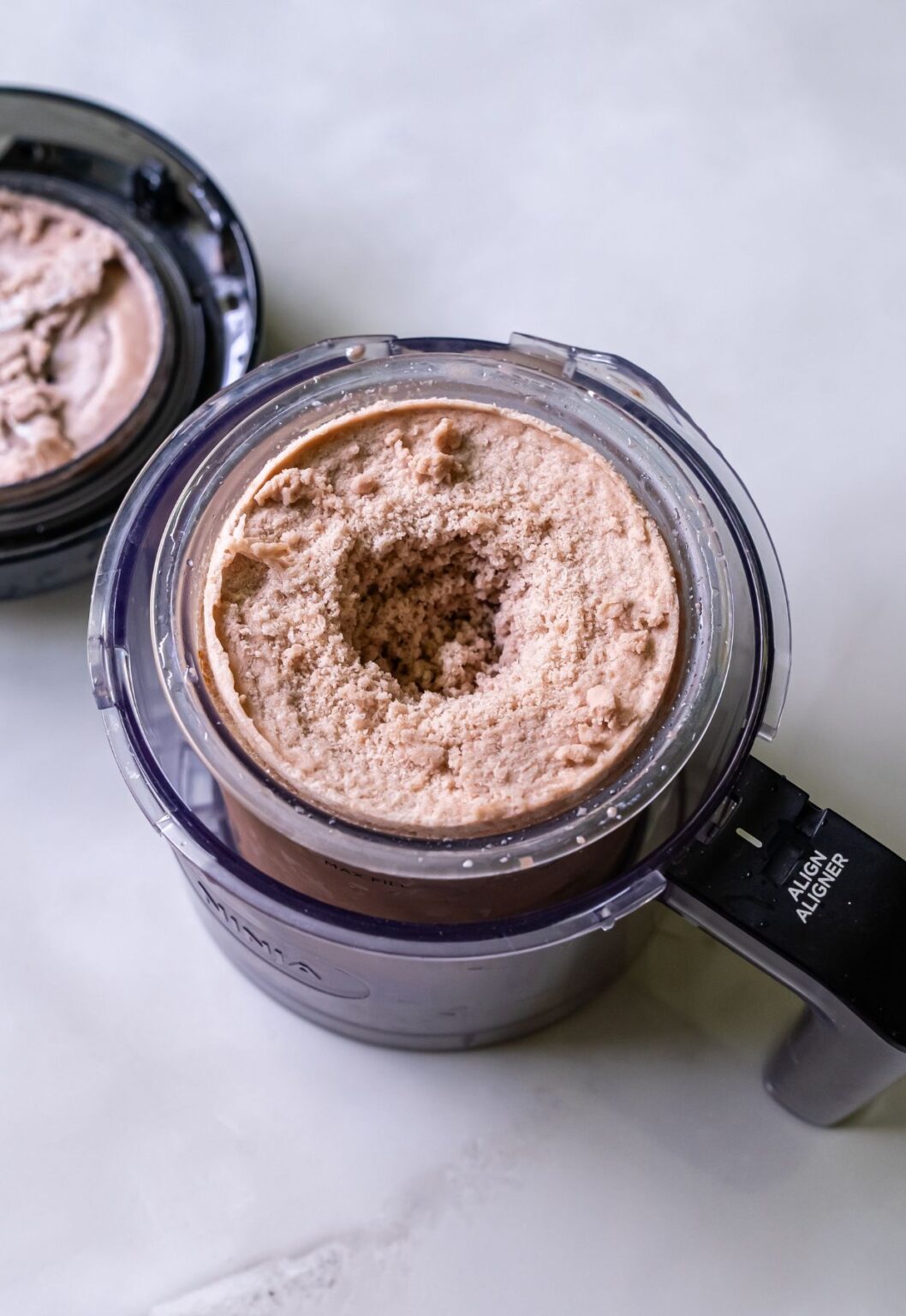 Top view of high protein chocolate ice cream swirled in a clear Ninja blender pint.
