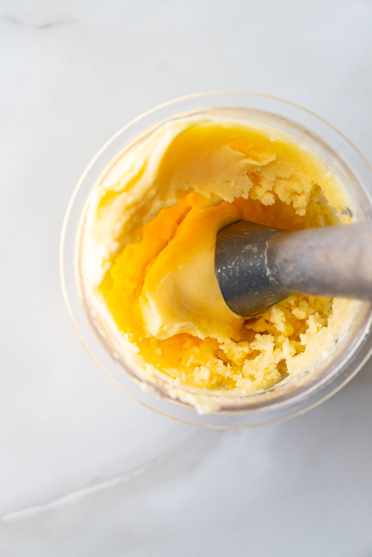 peach sorbet in a pint with an an ice cream scooper.
