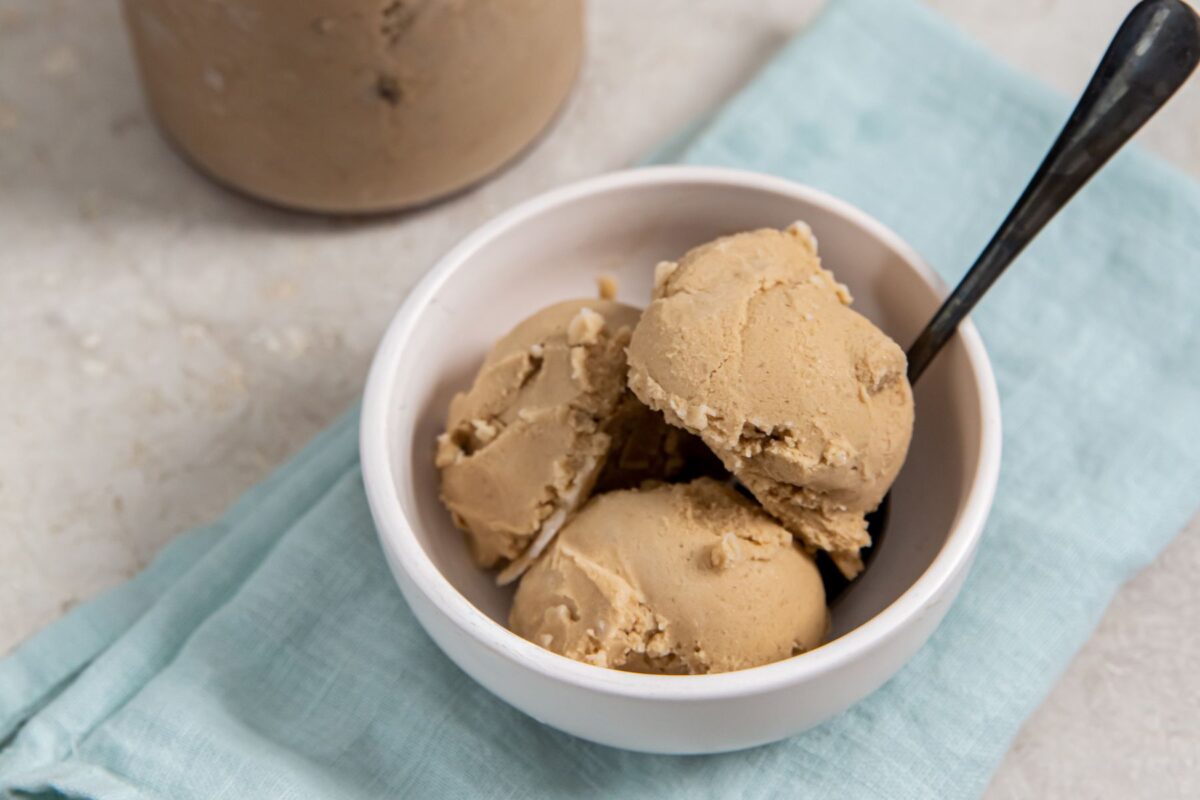 Coffee Ice Cream in a white bowl over a turquoise napkin with a black spoon